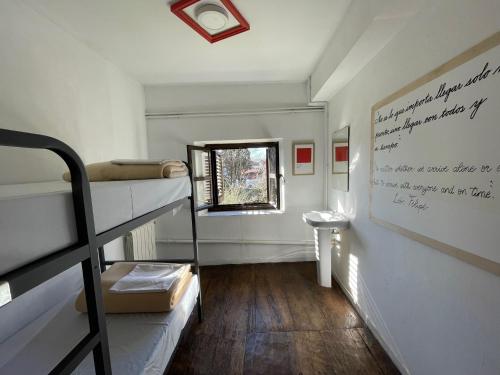 a room with two bunk beds and a window at Albergue de peregrinos El Convento in Santillana del Mar