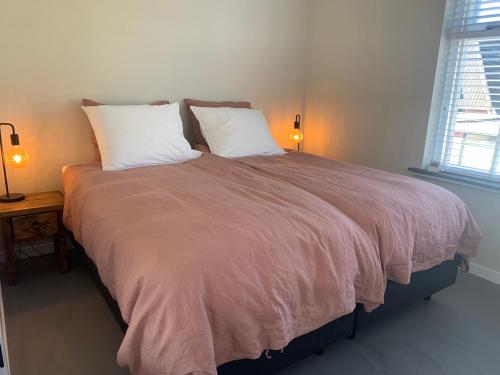 um quarto com uma cama grande e 2 almofadas em Appartement Het Bovenhuys em Baflo