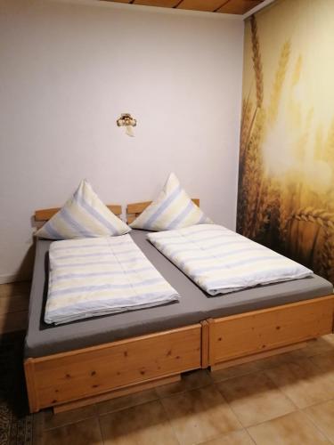 uma cama num quarto com duas almofadas em Schöne Wohnung im Herzen von Burgstädt em Burgstaedt