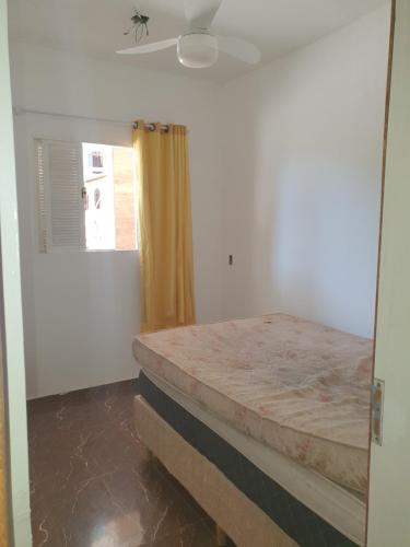 a bedroom with a bed and a window at Casa 05 quartos em Marataízes in Marataizes