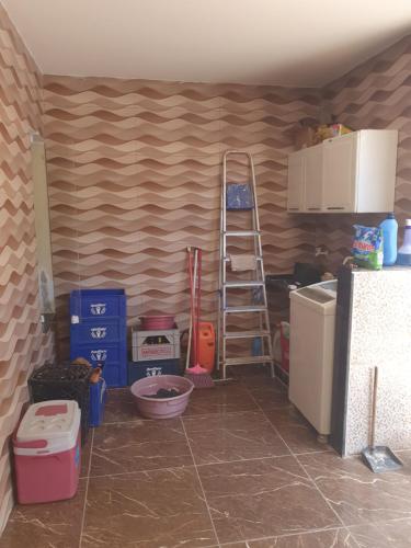 a kitchen with a ladder next to a refrigerator at Casa 05 quartos em Marataízes in Marataizes