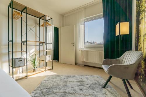 een woonkamer met een stoel en een raam bij Exklusive Stadtvilla-190qm- Parkplatz- 3Schlafzimmer- 2 Bäder- Netflix- Waschmaschine- 4 Etagen-nähe Theater in Cottbus
