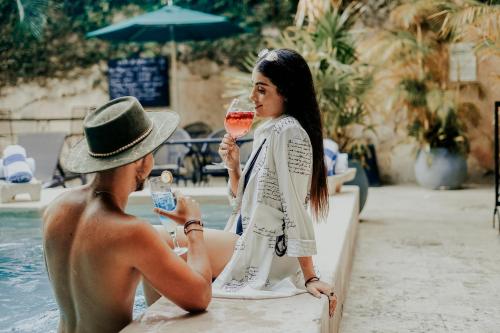 a man and woman drinking wine by a pool at Piedra de Agua Merida in Mérida
