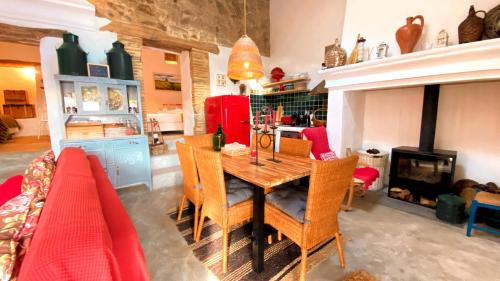 a dining room with a table and chairs and a fireplace at Monte Refúgio do Silêncio in Portalegre