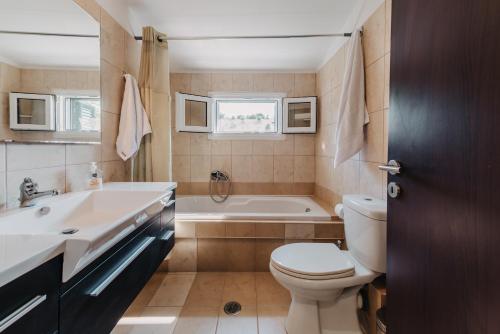 a bathroom with a tub and a toilet and a sink at Villa Varka in Vitalades