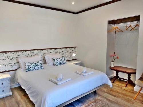 una camera da letto con un letto bianco con due asciugamani sopra di Villa Nova Madeira in Funchal Casa A and B a Funchal