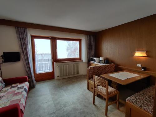 pokój hotelowy ze stołem, stołem i krzesłami w obiekcie Lärchenheim w mieście Obereggen
