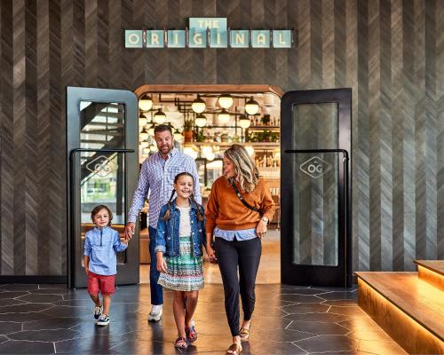 a family walking down a shopping mall at The Rally Hotel at McGregor Square in Denver