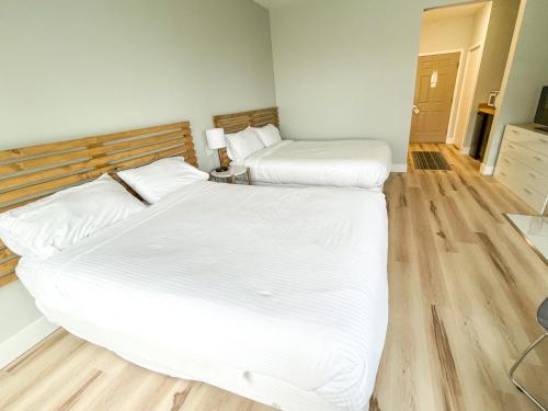 two twin beds in a room with wooden floors at Lake Bluff Inn and Suites in South Haven