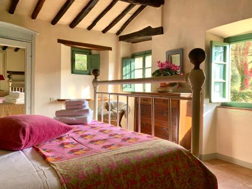 1 dormitorio con 1 cama y balcón con ventanas en Antico Borgo di Sugame, en Greve in Chianti