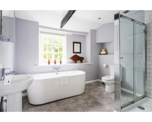 a bathroom with a tub and a sink and a toilet at Hatfield Cottage in Bath