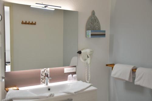 a bathroom with a sink and a mirror at Logis Hôtel Restaurant LE VIEUX FUSIL in Soings-en-Sologne