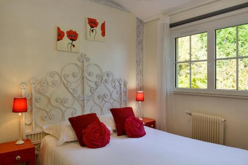 1 dormitorio con 1 cama blanca y 2 almohadas rojas en Logis Hôtel Restaurant LE VIEUX FUSIL, en Soings-en-Sologne