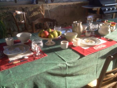 a table with a green table cloth with fruit on it at Le Château de Roquebère in Condom