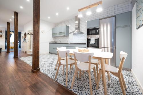 a kitchen and dining room with a table and chairs at Lavaderu Apartamento in Gijón