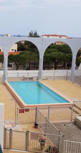 - une grande piscine dans un bâtiment avec une arche dans l'établissement Appart T2 - 4 pers - VILLAGE - 200m de la plage, au Barcarès