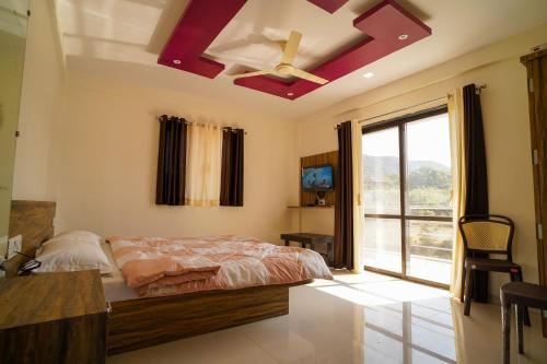 1 dormitorio con 1 cama y ventilador de techo en ELITE HOME en Mahābaleshwar