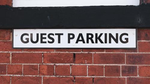 un panneau indiquant le stationnement sur un mur en briques dans l'établissement Crescent Lodge Guest House, à Whitby