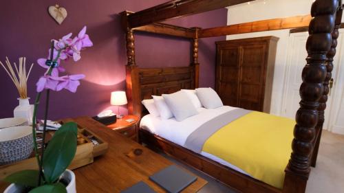 a bedroom with a bed and a table and purple walls at Rowrah Hall in Arlecdon