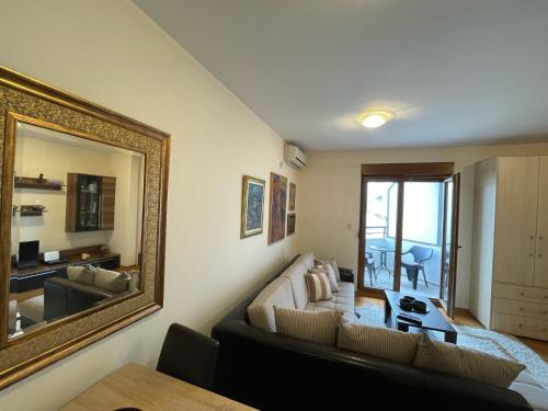 a living room with a couch and a large mirror at Exclusive studio, great location in Podgorica
