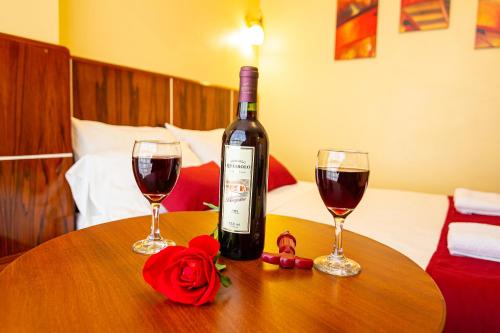 una bottiglia di vino e due bicchieri su un tavolo di Hotel California a Juliaca