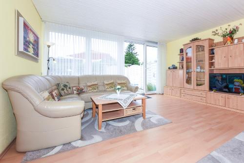ein Wohnzimmer mit einer Couch und einem Tisch in der Unterkunft Ferienhaus Ingrid in Bensersiel