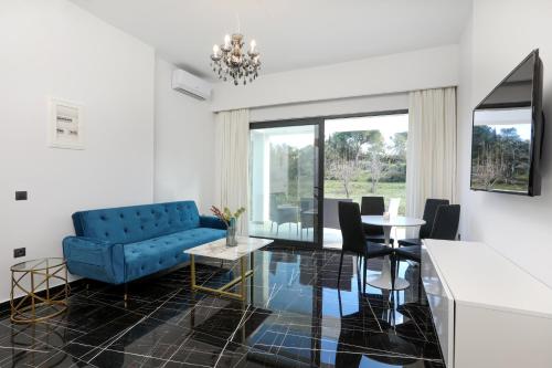 a living room with a blue couch and a table at Rans Luxury Villas & Suites in Corfu with swimming pool in Gouvia