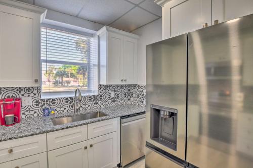 a kitchen with white cabinets and a stainless steel refrigerator at Serene Daytona Beach House with Private Yard! in Daytona Beach