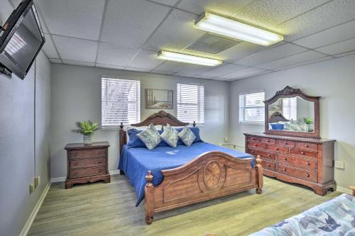 a bedroom with a bed with blue sheets and a mirror at Serene Daytona Beach House with Private Yard! in Daytona Beach