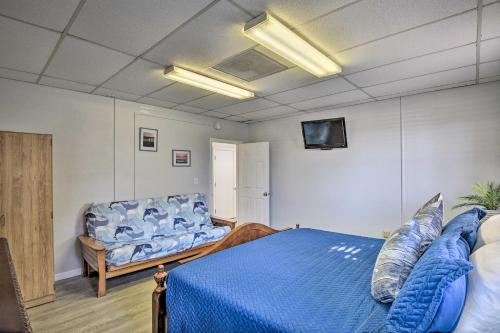 a bedroom with a blue bed and a couch at Serene Daytona Beach House with Private Yard! in Daytona Beach