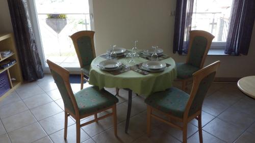 uma mesa de jantar com uma toalha de mesa verde e cadeiras em Haus Sonja em Adenau