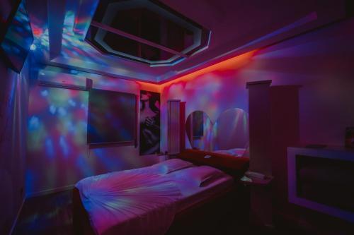 a bedroom with pink and blue lights and a bed at Motel Príncipe Encantado in Mealhada