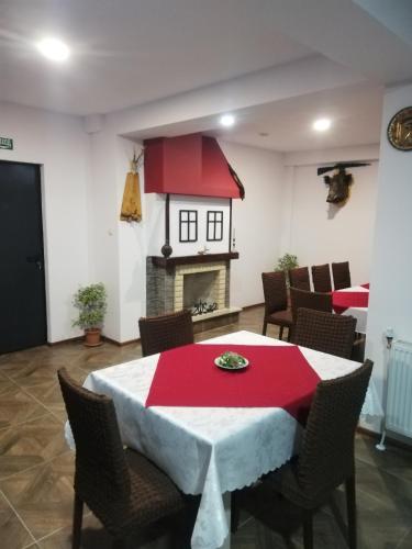 un comedor con una mesa roja y blanca y una chimenea en ВИЛА ОБЗОР с Проглед община Чепеларе, en Progled