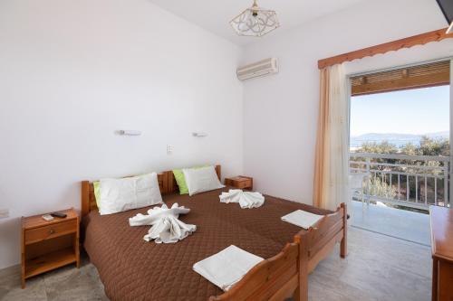 a bedroom with a large bed with towels on it at Corfu Star Apartments in Benitses