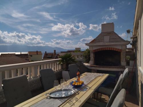 een houten tafel op een balkon met een open haard bij Apartments Maja i Mate in Sućuraj