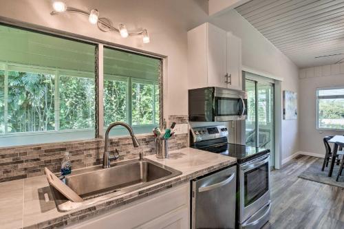 eine Küche mit Spüle und Mikrowelle in der Unterkunft Sunny Pahoa Retreat Snorkel, Hike and Shop! in Pahoa