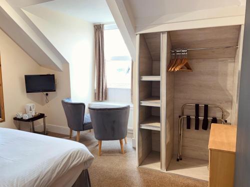 a bedroom with a bed and a desk and a chair at Membly Hall Hotel in Falmouth