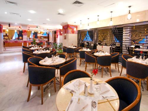 a restaurant with tables and chairs in a room at Elaf Ajyad Hotel Makkah in Makkah