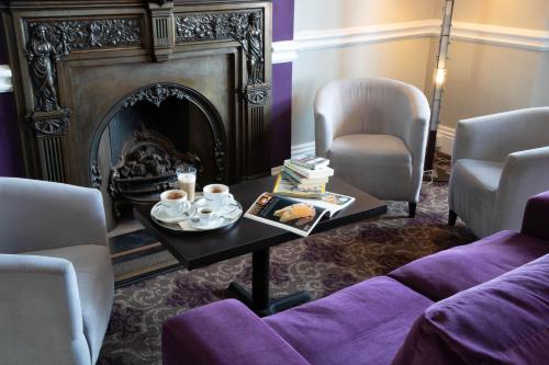 a living room with a fireplace and a coffee table at The Seafront Hotel by Compass Hospitality in Llandudno