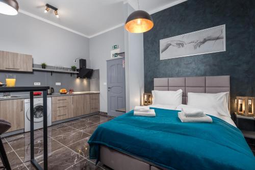 a bedroom with a blue bed and a kitchen at Apartments Piccola Venezia in Rijeka