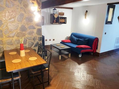 - un salon avec un canapé bleu et une table dans l'établissement Apartamento Rural Bella Vista, à Villaluenga del Rosario