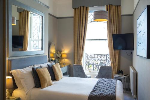 um quarto de hotel com uma cama e uma janela em Gloucester House em Weymouth