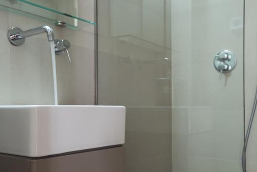 a bathroom with a glass shower with a sink at Kera Studios in Kalyves