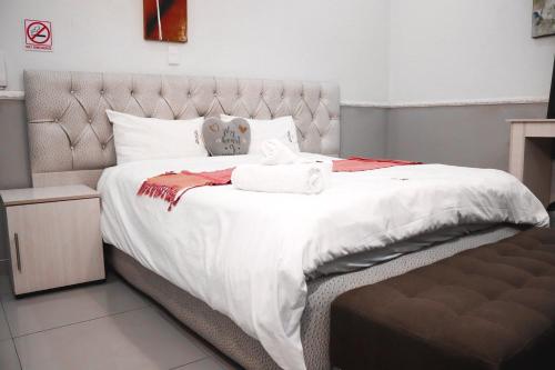 a bedroom with a large bed with white sheets at Gold Crown International Hotel With Complementary Breakfast and WiFi in Johannesburg