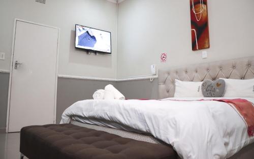a bedroom with a bed and a tv on the wall at Gold Crown International Hotel With Complementary Breakfast and WiFi in Johannesburg