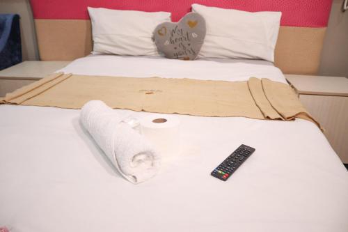 a bed with towels and a remote control on it at Gold Crown International Hotel With Complementary Breakfast and WiFi in Johannesburg