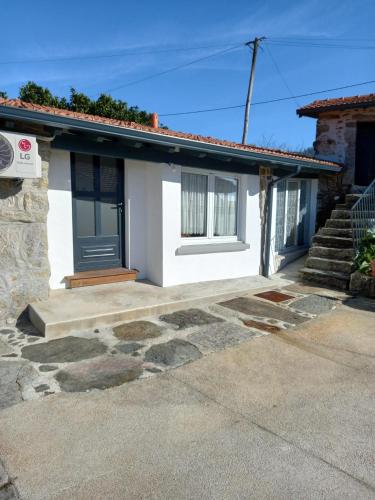 a white house with a door and stairs at Harrisko etxea in Viana do Castelo