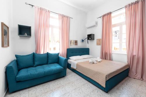 a bedroom with a bed and a blue couch at Classic-Style Apartment Nearby the Old Town in Rhodes Town