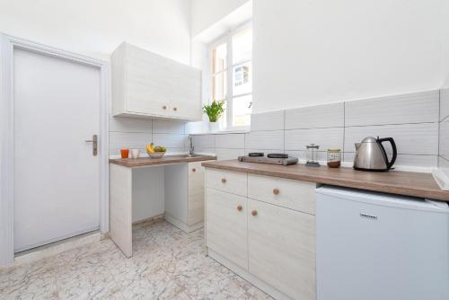 a white kitchen with white cabinets and a counter at Classic-Style Apartment Nearby the Old Town in Rhodes Town