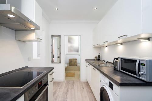 a kitchen with a sink and a microwave at Budget Studio Kreuzberg - Lachmannstr 3 HH in Berlin